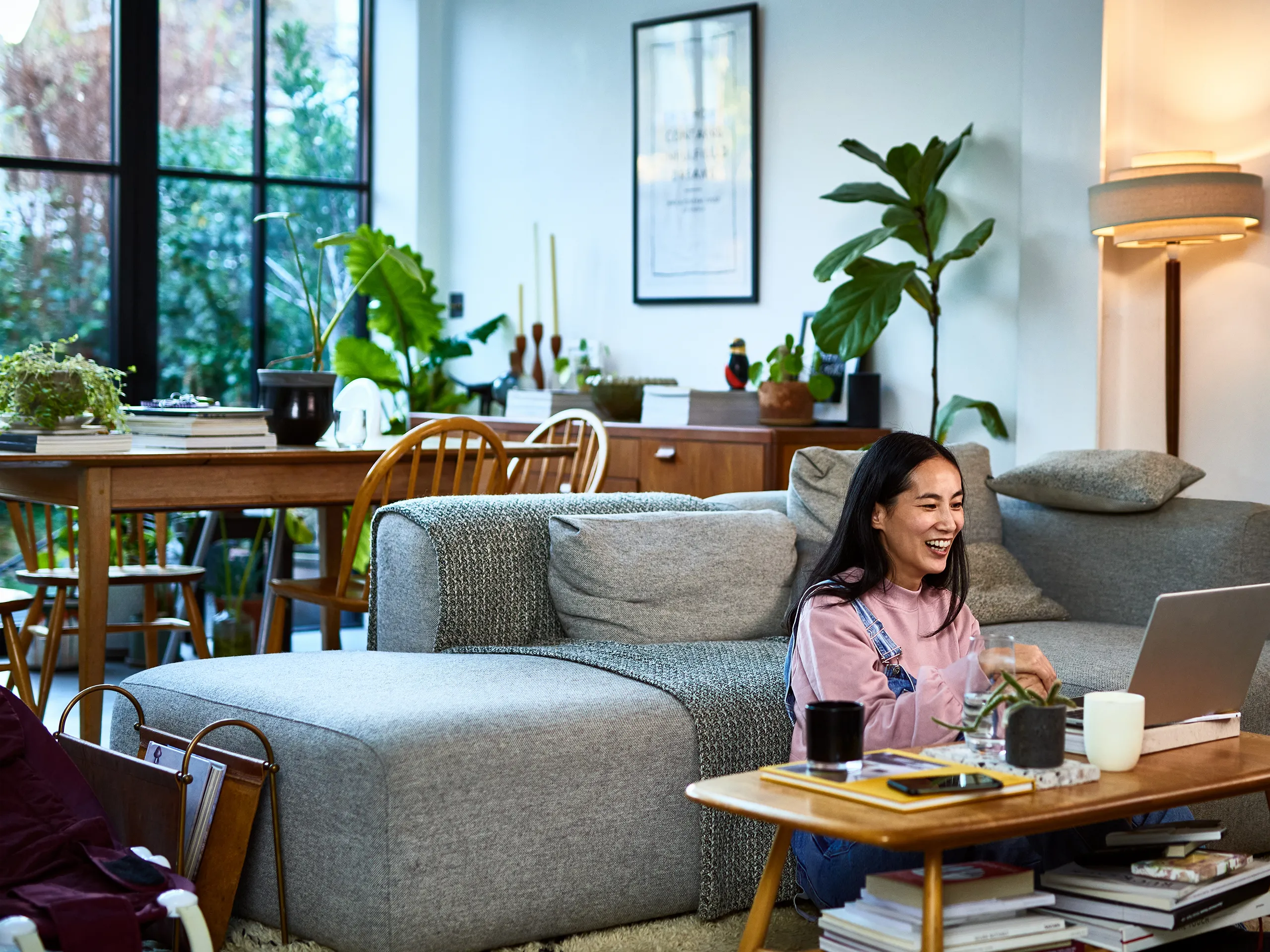 Frau sitzt im Wohnzimmer am Laptop